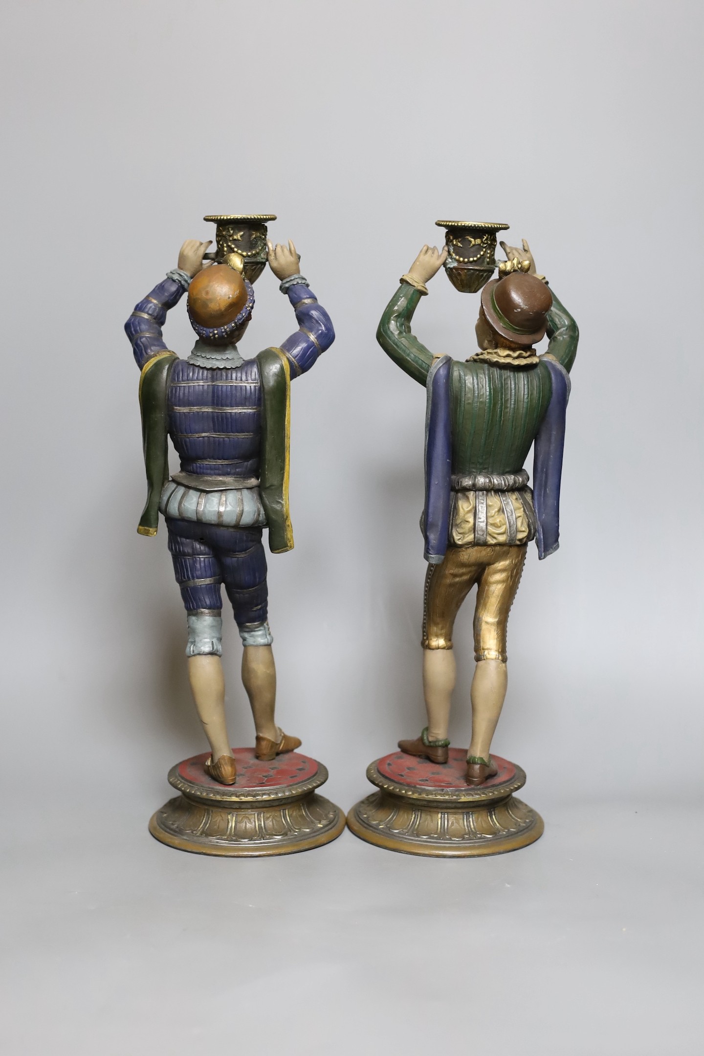 A pair of painted spelter figural candlesticks, 35.5 cms high